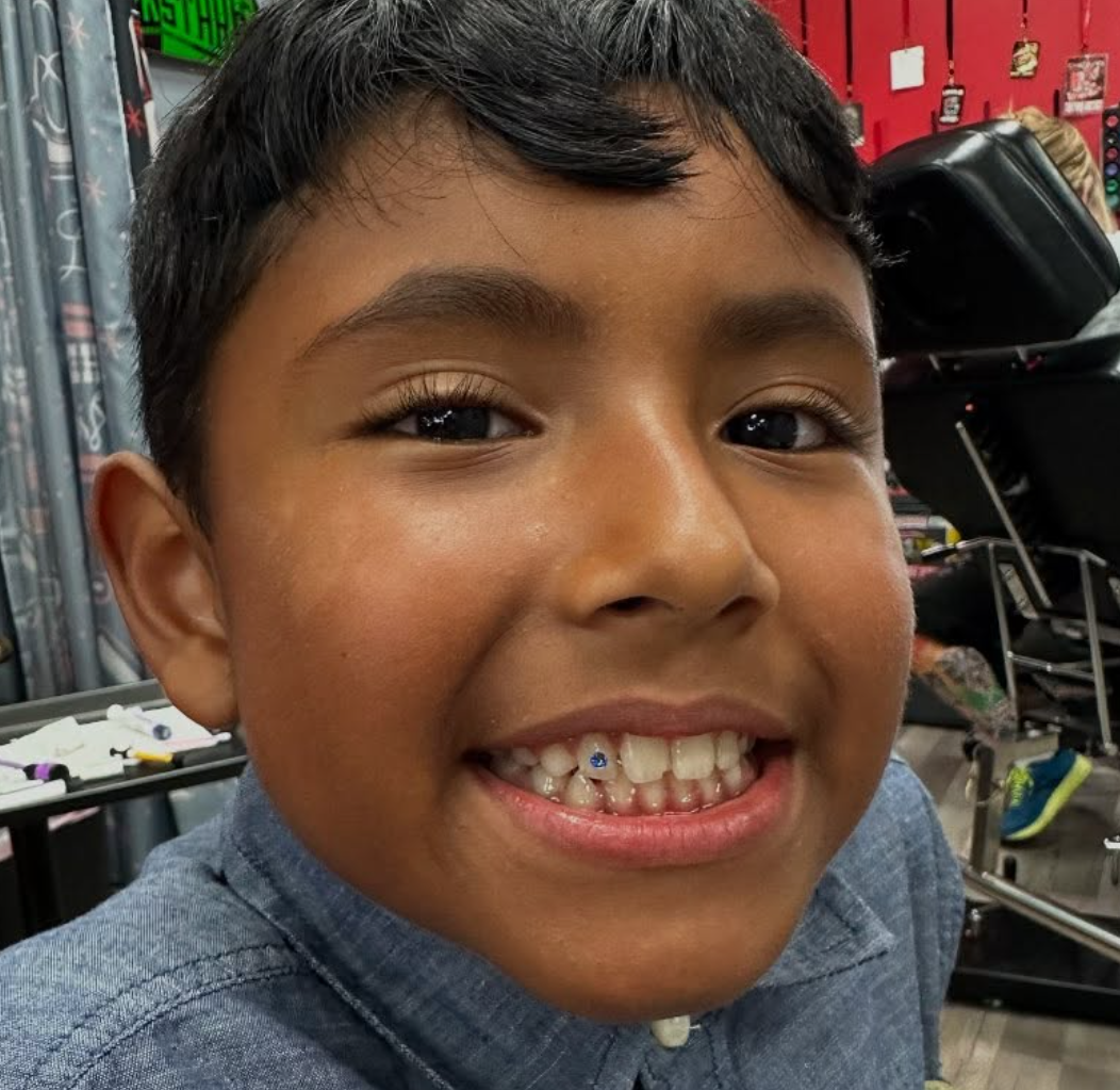 Kid tooth gem smiling at Darkstar Tattoo Riverside CA