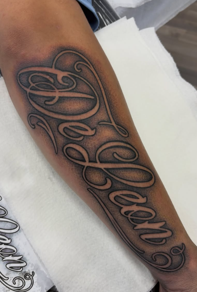 Black and grey script lettering forearm tattoo by Looney at Darkstar Tattoo Riverside CA