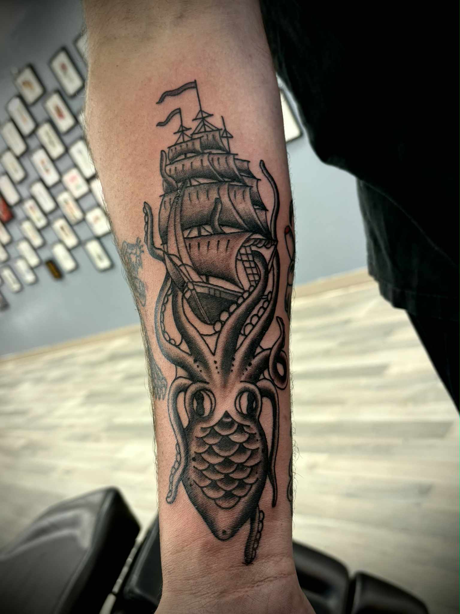 Black and grey kraken ship forearm tattoo at Darkstar Tattoo Riverside CA