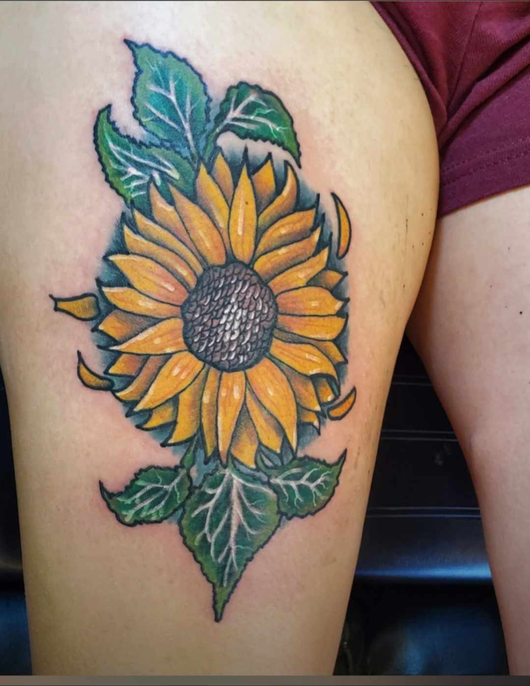 Color sunflower thigh tattoo at Darkstar Tattoo Riverside CA