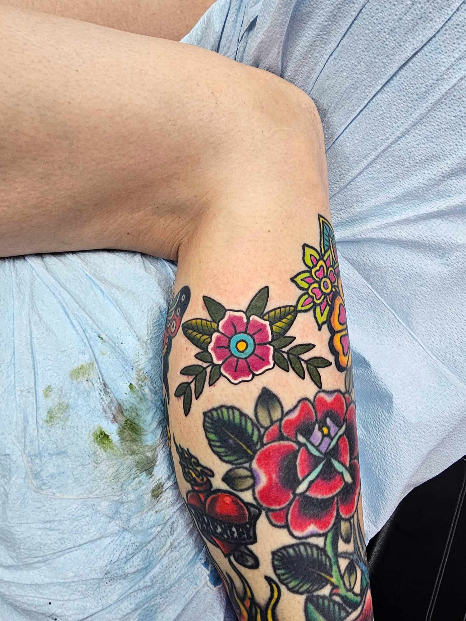 Traditional bright color flower leg tattoo at Darkstar Tattoo Riverside CA