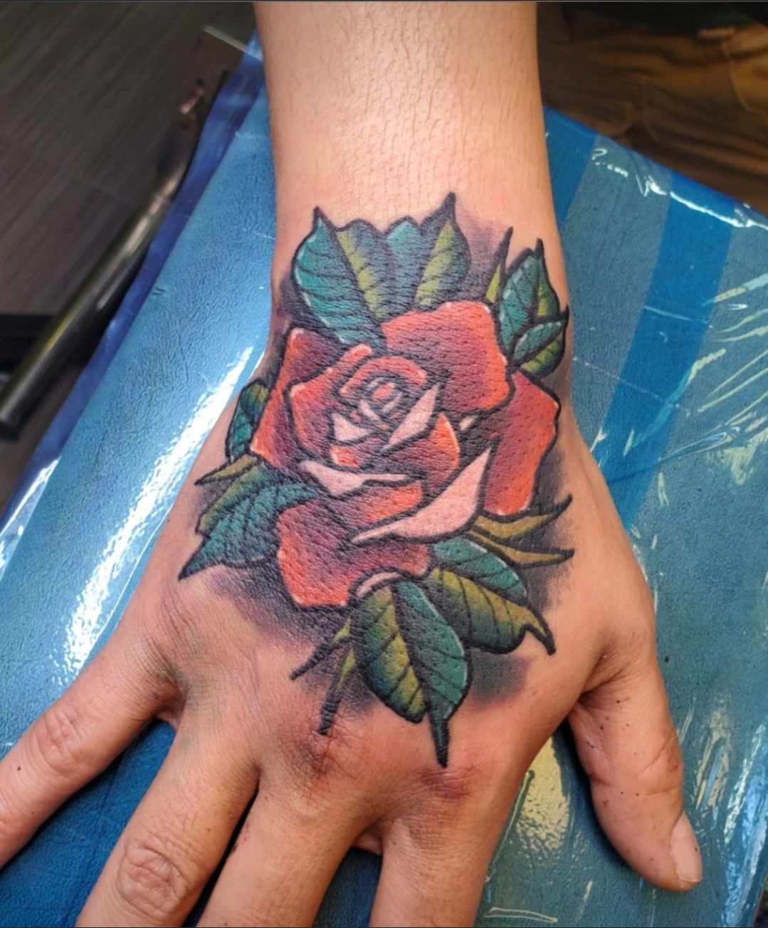 Traditional color rose hand tattoo at Darkstar Tattoo Riverside CA